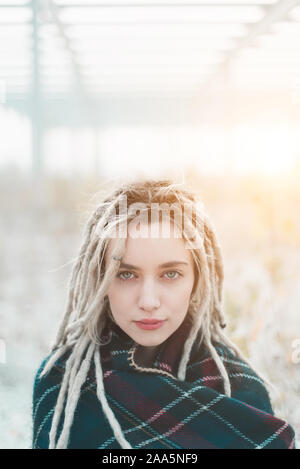 Jeune femme avec des dreadlocks portant poncho cape portrait Banque D'Images