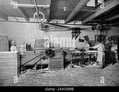 De Guerre - Industries - fabrication de bonbons au chocolat BONBONS PIRIKA CO. ca plaque. 1917-1918 Mogul machine- vide le conseil d'amidon qui sont déjà plein de les "centres.' 'la vis d'amidon, de renouvellements, les conseils, 'imprime' les moules, jette les centres, et nettoie les préparer pour tremper. Banque D'Images