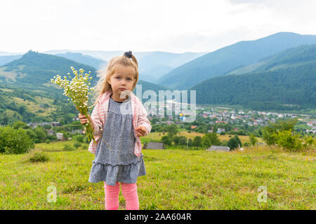 Petite fille à la tenue à huis clos et bouquet de fleurs à la main Banque D'Images