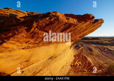 Falaises de grès qui ont été freinée par l'érosion accrocher précairement au-dessus du sol du désert dans la région du lac Powell. Banque D'Images