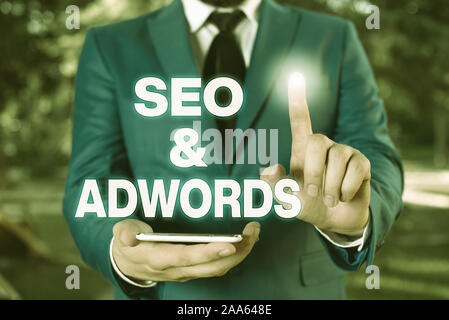 Main conceptuel montrant l'écriture Seo et Adwords. Concept signifiant payer par clic marketing numérique Google Adsense Businessman avec doigt en fr Banque D'Images