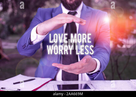 La main conceptuel montrant l'amour plus inquiéter moins. Sens concept ont une bonne attitude motivation se rendre aimable à profiter de la vie Homme en face du tableau. Mob Banque D'Images