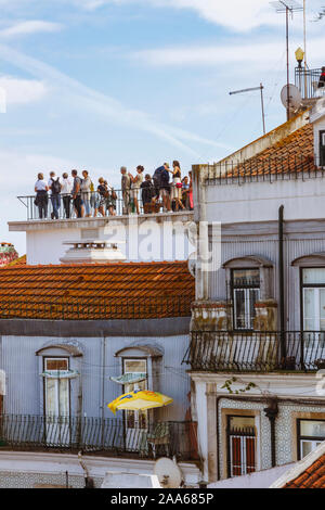 Lisbonne, Portugal : un grand groupe de touristes sont à la terrasse d'observation au sommet d'un vieux bâtiment dans le Miradouro das Portas do Sol de vue. Banque D'Images