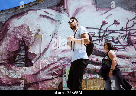 Lisbonne, Portugal - Mai 25th, 2018 : les touristes devant une peinture murale de la rue dans le quartier de Cais do Sodré. Banque D'Images