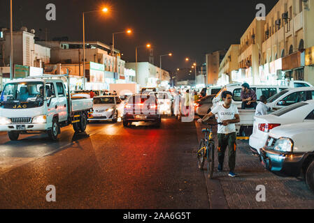 Le trafic et les voitures en stationnement dans la rue la nuit, en face de Souq Al-Haraj, Doha, Qatar Banque D'Images