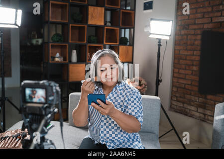 Les vieilles femmes faire une vidéo pour son blog sur les cosmétiques Banque D'Images