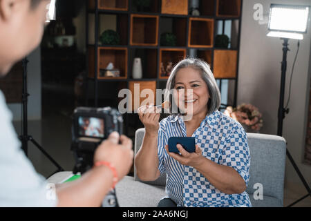 Les vieilles femmes faire une vidéo pour son blog sur les cosmétiques Banque D'Images