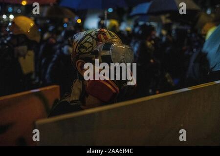 Hong Kong, Chine. 16 Nov, 2019. Masque respiratoire à l'aide d'un manifestant se protège avec un bouclier improvisé pendant les affrontements avec la police anti-émeute.la police antiémeutes et manifestants ont affronté dans les environs de Hong Kong Polytechnic University après une journée de calme relatif, les affrontements entre les manifestants et la police anti-émeute a commencé la nuit lorsque la police a tenté de briser les barricades en tirant des gaz lacrymogènes et ont été reçus par des manifestants qui ont répondu avec des cocktails molotov et des briques. La plupart des combats concentrés à l'intersection de l'entrée principale de l'école. Credit : SOPA/Alamy Images Limited Live News Banque D'Images