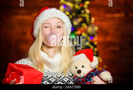Faire des bulles avec de la gomme. Seulement amusant sur mon esprit. Fille du Père Noël, faisant de grands avec de la gomme à bulles. Funny face close up. Adorable woman blowing bubble. Fille de noël faites bubble-gum. Respirez doucement. Banque D'Images