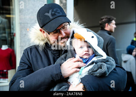 Stirling, Stirlingshire, UK. 17 novembre, 2019. Un homme avec kid hid regarder le défilé passer par lors de l'événement.Stirling est sorti pour commencer la période des fêtes de Noël avec leur lumière tournez sur l'événement, c'est un événement annuel qui a lieu le 17 novembre. Conseil Stirling organiser un concours pour voir qui sera chanceux et s'asseoir à côté de Santa pour la parade et d'avoir l'honneur de faire le commutateur. Cette année a vu Clara-Louise Hamill et sa famille d'avoir l'honneur. Crédit : Stewart Kirby/SOPA Images/ZUMA/Alamy Fil Live News Banque D'Images