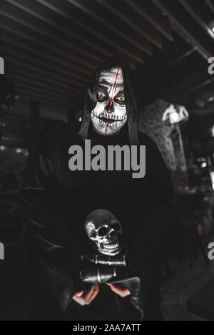 Halloween, vacances, masquerade concept - le portrait d'un homme avec tête de maquillage sur fond sombre Banque D'Images