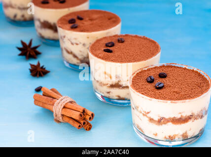 Tiramisu dessert dans un verre sur un fond bleu décoré de menthe Banque D'Images