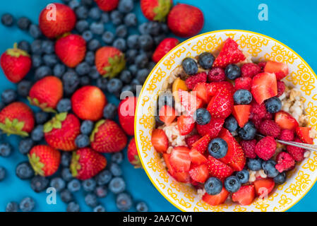 Gruau d'avoine avec des bleuets, des fraises et du muesli sur fond de bois. Petit-déjeuner diététique. Banque D'Images