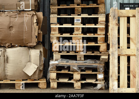 Stock des piles de palettes en bois et des boîtes de carton dans une cour prête à éclater et le recyclage Banque D'Images