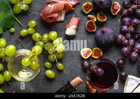 Buffet avec vin snack-set ou apéritif. La viande italienne, des verres de vins, fromages, raisins et figues. Banque D'Images