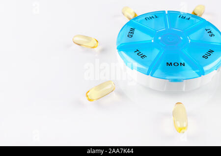 Capsules omega avec une boîte de pilules sur fond blanc Banque D'Images