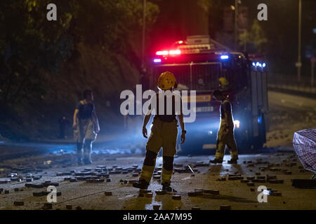 Hong Kong, Chine. 18 Nov, 2019. Pompiers à pied sur le Chatham Road South une croix de chemin de la Maison Bleue à l'extérieur de l'école Wan lors des protestations.siège à l'Université Polytechnique. Surround de la police du campus de l'université après avoir pro-démocratique manifestants ont bloqué le port, tunnel et la route principale à l'extérieur du campus. Protestation de Hong Kong continuent pour le sixième mois. Une grève à l'échelle de la ville a appelé à commencé le lundi 11 novembre, 2019 qui a parties de Hong Kong d'arrêter en tant que stations de métro fermées et plusieurs barrages routiers ont été érigés. Credit : SOPA/Alamy Images Limited Live News Banque D'Images