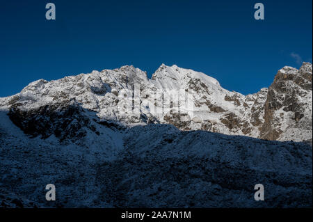 La lumière du soleil illumine la pointe de Naya Kanga, qui éclipse la Gangja La, un col menant hors de la vallée du Langtang, au Népal. Banque D'Images