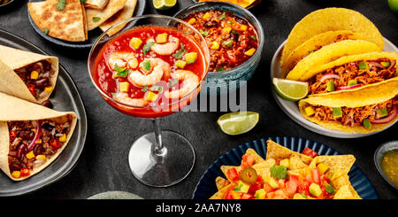 La nourriture mexicaine panorama sur un fond noir. Un cocktail de crevettes, chili con carne, tacos et autres plats Banque D'Images