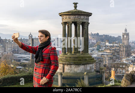 Edinburgh, Royaume-Uni. Novembre 20, 2019 Photo : un touriste habillé en tartan, prend une photo de la skyline de Calton Hill dans le soleil d'hiver. Credit : Riche de Dyson/Alamy Live News Banque D'Images