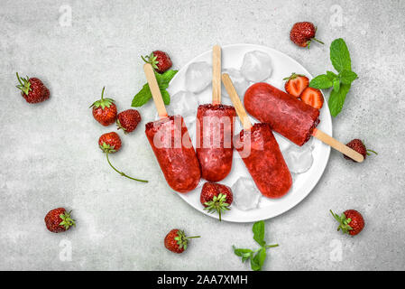 Sucettes glacées faites maison avec des fraises, des sucettes glacées sur des bâtons, haut Vue, télévision lay Banque D'Images