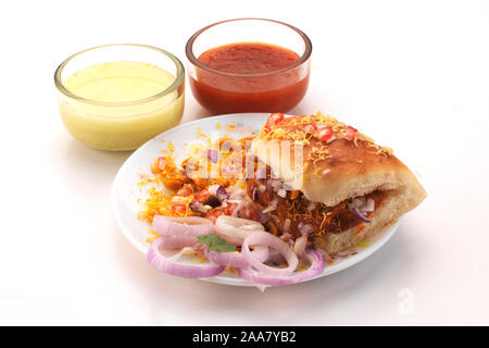 Kutchi Dabeli est un Indien point snack servi avec des graines de grenade et la coriandre dans une plaque en céramique blanche. C'est un populaire festival Navratri, sélectionnez des aliments Banque D'Images