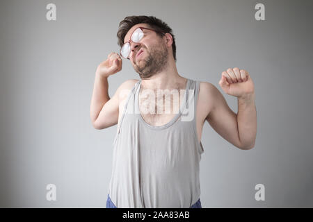Matin qui s'étend de jeune homme barbu avec de grands verres. Être paresseux. Studio shot Banque D'Images