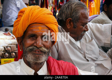 Bikaner, Rajasthan, Inde : portrait d'un homme indien âgé avec turban jaune, derrière lui un autre homme de profil. Banque D'Images