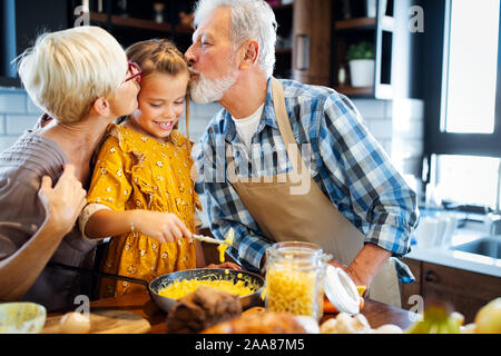 Heureux grands-parents avec leurs petits-enfants ce qui fait du petit déjeuner dans la cuisine Banque D'Images