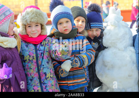 Un groupe d'enfants a fait un bonhomme de neige sur un carré d'hiver, jeux d'enfants, Vacances Banque D'Images