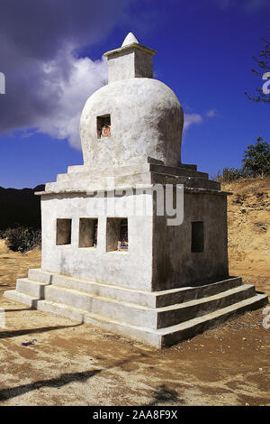 Objet de dévotion bouddhiste ou chorten et les drapeaux de prières avec des contreforts d'ombre sous un ciel dramatique au Gul Bhanjyang dans la région du centre de l'Helambu Banque D'Images