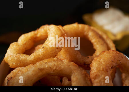 Libre de quelques calamares a la romana, Fried squid battues typique de l'Espagne, les anneaux sur une table rustique en bois foncé et un petit mortier jaune avec aiol Banque D'Images