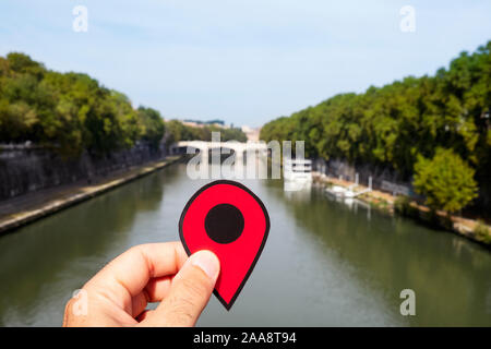 Libre de la main d'un homme de race blanche tenant un marqueur rouge au Tibre en passant par Rome, Italie, et le Giuseppe Mazzini pont dans le background Banque D'Images