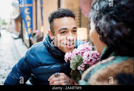 Portrait d'un homme regardant sa petite amie assis dehors un café Banque D'Images