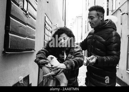 Jeune couple cherche à leur chien dans un panier d'un vélo en Europe Banque D'Images