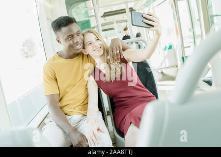 Garçon et fille dans l'amour en prenant un bus sur les selfies Banque D'Images