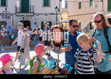 Sineu, Espagne. 09Th Oct, 2019. Un commerçant montre une fillette et son père comment ses cheveux bandes sont utilisées dans le marché d'Orthez. Les deux jeunes frères et sœurs sont à regarder. Chaque mercredi en jour de marché Sineu que principalement attire les touristes. Credit : Stephan Schulz/dpa-Zentralbild/ZB/dpa/Alamy Live News Banque D'Images