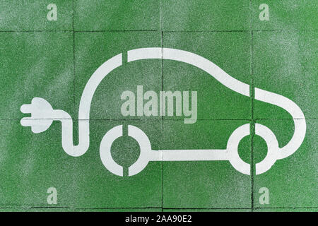 Le symbole d'une voiture avec un bouchon électrique présente un espace de stationnement pour voitures électriques Banque D'Images