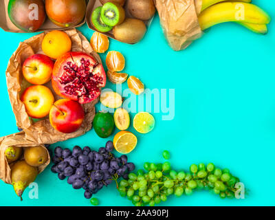 Les fruits et légumes riches en antioxydants, en vitamines et en fibres sur fond bleu. Zéro déchets food shopping, sacs en papier naturel eco style mise à plat Banque D'Images