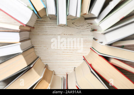 Cœur fait de livres sur fond rustique en bois blanc, vue du dessus Banque D'Images