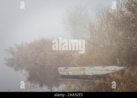 Vieille chaloupe au bord de l'eau dans un paysage gelé misty tôt le matin, photo prise au lac de Kotermeerstal les Pays-Bas, province Waals-brabant Banque D'Images