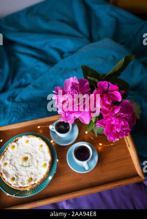 Beau matin cheesecake vanille, café, tasses bleu, rose de pivoines dans un vase en verre Banque D'Images