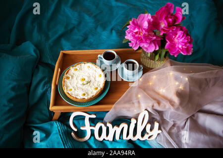 Beau matin cheesecake vanille, café, tasses bleu, rose de pivoines dans un vase de verre. Vue de dessus Banque D'Images