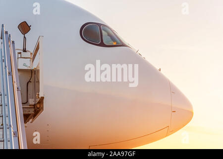 Side view close up sur le nez d'un avion de passagers au coucher du soleil Banque D'Images