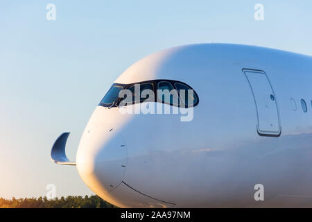 Side view close up sur le nez et l'aile d'un avion de passagers au coucher du soleil Banque D'Images