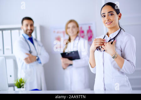 Smiling Female Doctor with Stethoscope arabe debout en face de son équipe à l'hôpital Banque D'Images