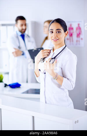 Smiling Female Doctor with Stethoscope arabe debout en face de son équipe à l'hôpital Banque D'Images