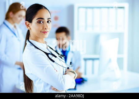 Femme médecin confiant devant team, smiling at camera, de l'équipe multiraciale avec femme médecin arabe Banque D'Images