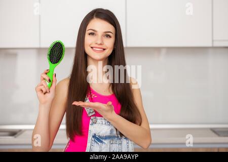 Girl est titulaire d'une brosse sans cheveux et souriant Banque D'Images