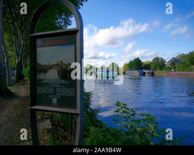 AJAXNETPHOTO. 2019. BOUGIVAL, FRANCE. - Peinture de PISSARRO - PANNEAU D'INFORMATION POUR LA PEINTURE DE L'artiste peintre impressionniste et Camille PISSARRO INTITULÉE "PENICHES SUR LA SEINE UNE BOUGIVAL, 1871', SITUÉ À L'ENDROIT OÙ SUR LES RIVES DE LA SEINE D'OÙ L'ARTISTE A FAIT LA PEINTURE PEUT ÊTRE VU PENICHES FREYCINET AMARRÉS SUR LA RIVE DU FLEUVE PRÈS DE BOUGIVAL LOCK ALORS QU'un remorqueur-pousseur ATTEND D'ENTRER DANS LA SERRURE. photo:JONATHAN EASTLAND/AJAXREF:GX8  20652 192609 Banque D'Images